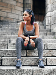 Taking a break before the final challenge. Full length shot of an attractive young sportswoman sitting down on a stairway outdoors in the city.