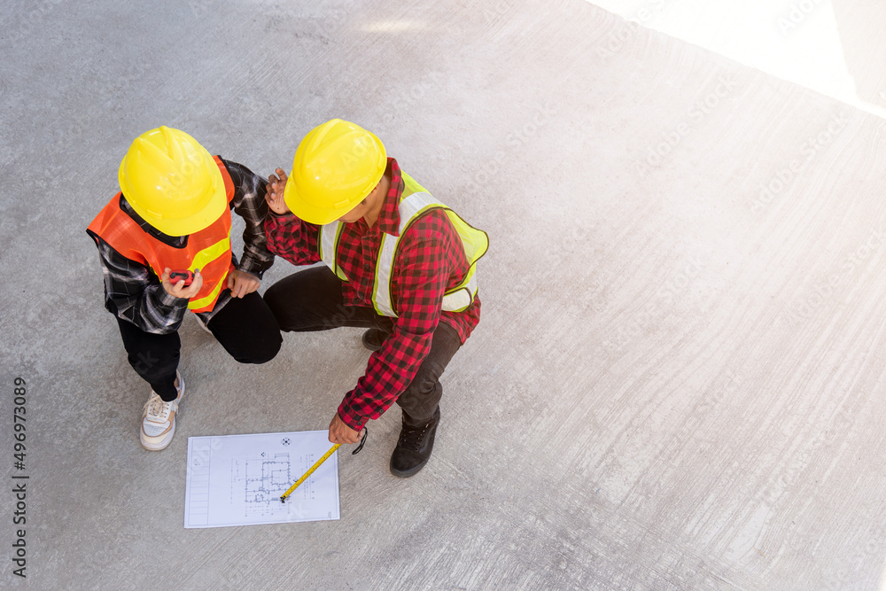 Poster architect and client discuss help create plan with blueprint of the building at construction site fl