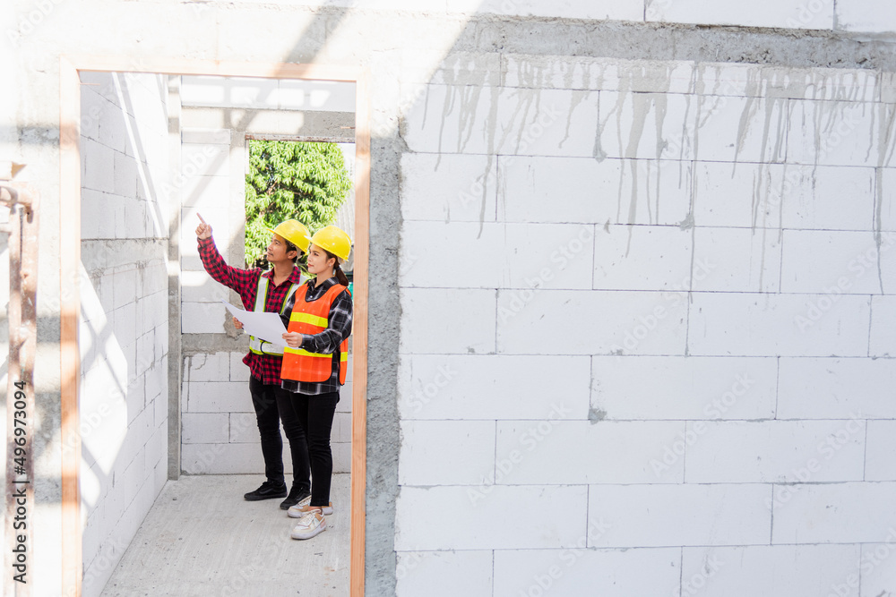 Poster architect and client discussing the plan with blueprint of the building at construction site. asian 
