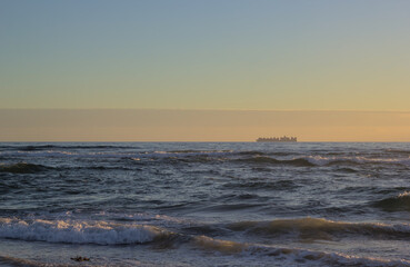 carguero o barco de carga en el horizonte de el mar bajo la puesta de sol