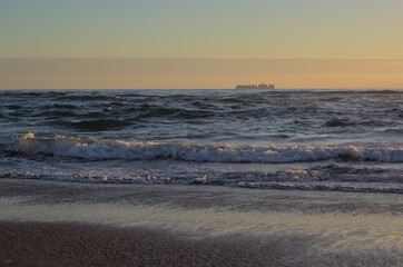 carguero o barco de carga en el horizonte de el mar bajo la puesta de sol
