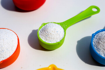 Detergent powder with measuring spoon for clothes washing. Laundry concept.
