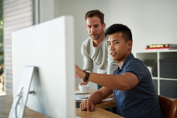 Sharing his ideas. Cropped shot of two designers working together on a project in an office.