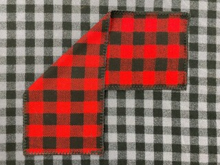 Checkered scarf on a background of black and white checkered fabric. Scarf top. Knitwear. Plaid....