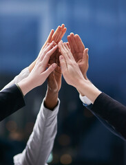 One team working towards one dream. Shot of a group of colleagues giving each other a high five in...