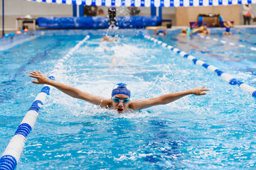 latin young man swimmer athlete wearing cap and goggles in a swimming training holding On Starting...