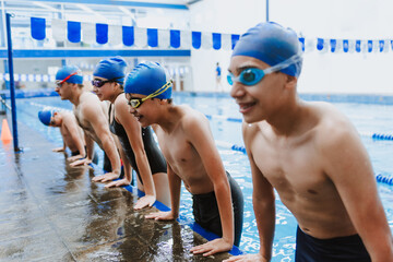 latin young man swimmer athlete and team wearing cap and goggles in a swimming training at the Pool in Mexico Latin America	