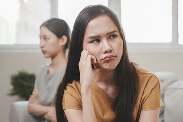 Unhappy lesbian, lgbt asian young two women, girl gay, couple love fight on sofa, relationship is in trouble. Different people are angry and use emotions at each other, expression of disappointmen.