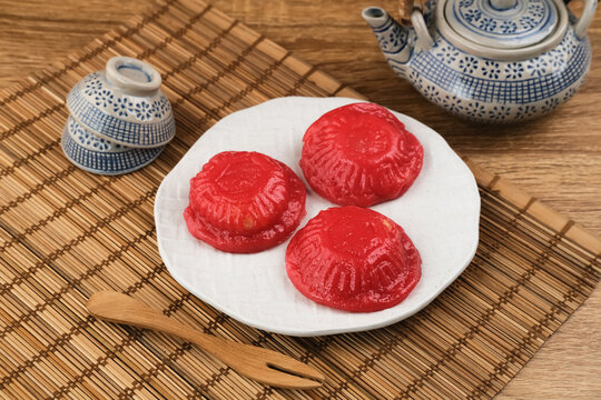 Ang Kue (Kue Ku) or Kue Thok, steamed Chinese pastry of glutinous rice flour with sweet mung bean paste filling. Sticky, chewy texture. Served on wooden background. Selective focus image.

