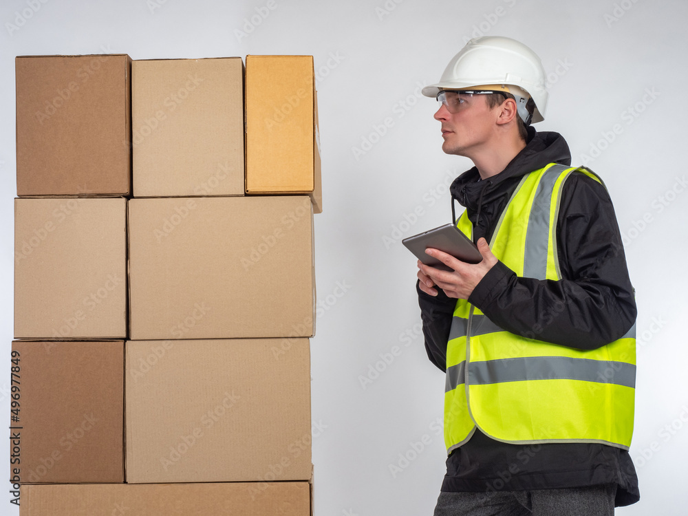 Aufkleber warehouse manager. guy next to boxes. warehouse worker with tablet computer. man in yellow vest and 