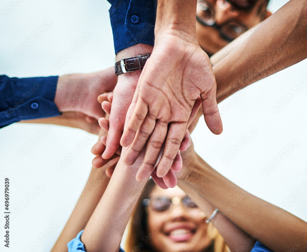 Poster theyre ready to go. low angle shot of a group of unrecognizable businesspeople joining their hands t