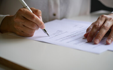 Businesswoman putting her signature on a contract agreement. Close up view with copy space.

