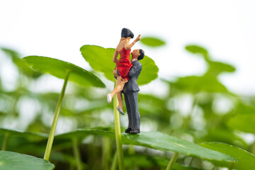 miniature lovers hug in green forest
