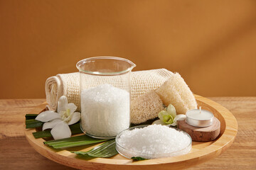 Close view of salt in spa decorated with towel and candles in wooden tray for exfoliating advertise...