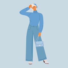 A girl with blond hair and a short haircut is dressed in a turtleneck and jeans. In the hands of a bag. Fashion clothes. Blue colors. Girl model posing for a photo.