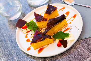 Portion of delicious custard tart with whipped cream, strawberry, chocolate and caramel sauce