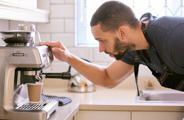 Ive been looking forward to this cup of coffee. Shot of a young man preparing a cup of coffee.