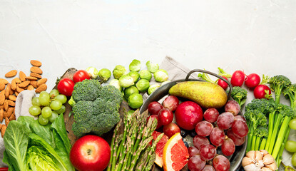Delicious raw fruits and vegetables on light background.