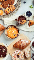 Dessert table with all kinds snacks on light background.