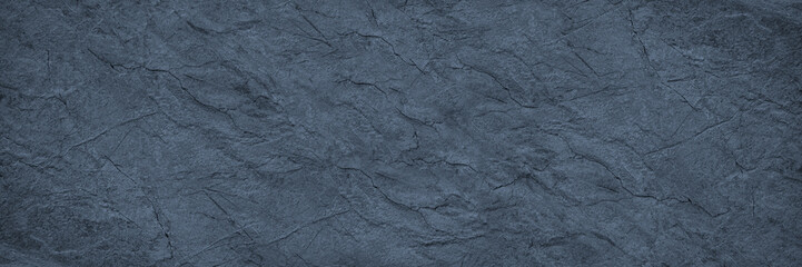 Blue gray stone texture. Toned rough rock surface. Close-up. Grunge background with copy space for design. Wide banner. Panoramic.