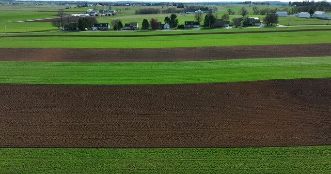 Rural farmland fields in spring planting season in Lancaster County Pennsylvania USA. Green and brown stripe pattern in colorful aerial drone scene.