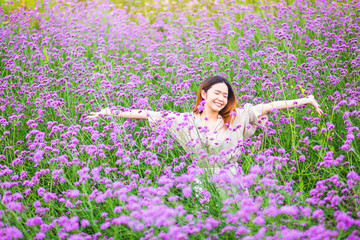 Attractive beautiful woman rise up her arms with happiness freedom in the middle of flower gardens