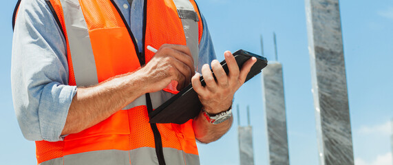 close-up, engineer manager using tablet, building, construction site. inspecting and working at construction site. banner image