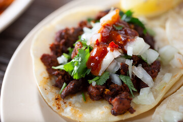 A closeup view of a plate of an al pastor street taco.