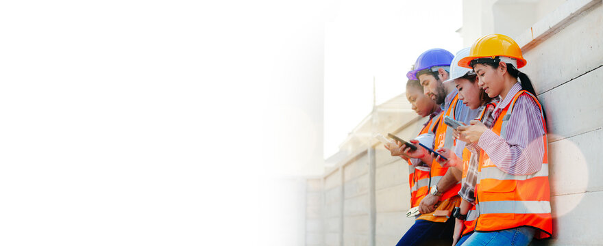 Banner image of happy construction workers in safety clothing. Caucasian male and female group Asians leaning against a wall at a construction site