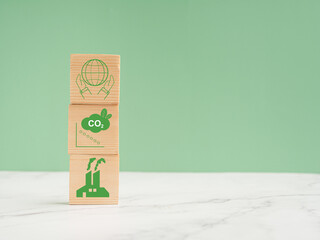 Net-zero greenhouse gas emissions target. Wooden cubes with green icons over a marble floor against...