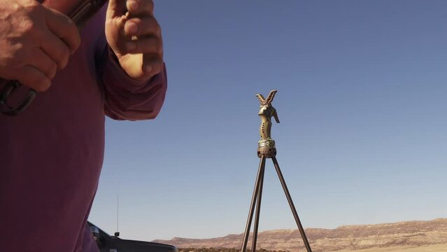 Man clears his rifle after taking a shot.