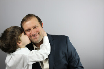 Father and son cheek kiss
