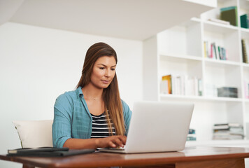 Ill have this blog post finished in no time. Shot of a focussed freelancer using her laptop while...