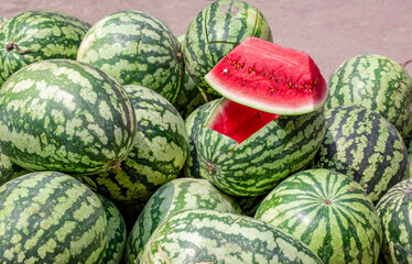 A pile of whole and sliced watermelons at the fruit shop for sales