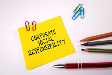 Corporate Social Responsibility. Yellow sheet of paper and stationery on a white background
