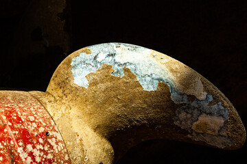 Part of an old bronze ship propeller with traces of corrosion and peeling paint, close-up....