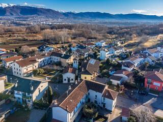 Naklejka na ściany i meble Central Friuli villages seen from above. Between hills and snow-capped mountains. Martinazzo of Cassacco.