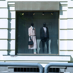 Two mannequins in a shop window on a showcase