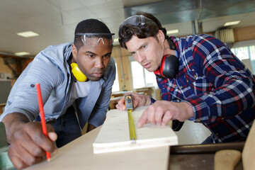 carpenter and apprentice working in studio