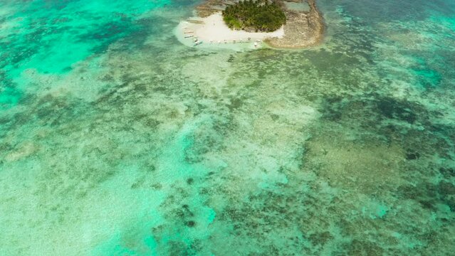 Aerial view of sandy beach with tourists on tropical island with palm trees and turquoise water. Guyam island, Philippines, Siargao. Summer and travel vacation concept