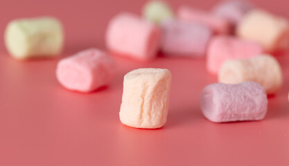 Multicolored candies on a pink background. Close-up