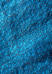 Naklejka premium Cracked blue paint on fabric as an abstract background.