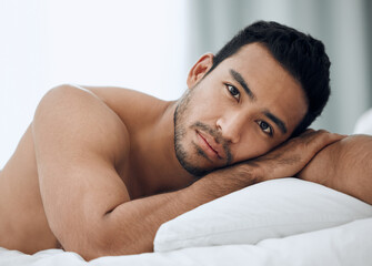 I could do with some company. Shot of a handsome young man lying on his bed.