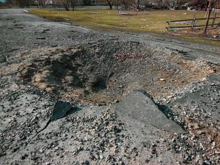 Crater on the road after the explosion of a Russian rocket