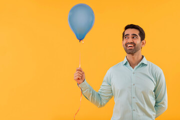 Portrait of happy young man holding balloon in hand © IndiaPix