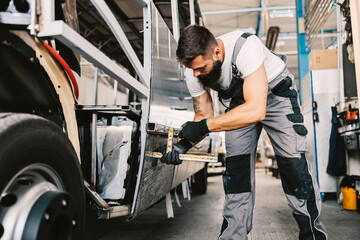 A heavy industry worker building a bus at workshop.