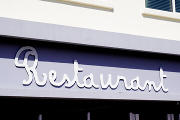 restaurant text sign on grey facade building city street storefront