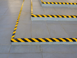 Black and yellow hazard warning safety stripe tape stuck on the stairs.