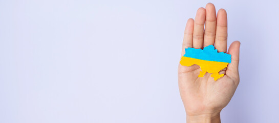 Support for Ukraine in the war with Russia, Hands holding the shape of Ukraine border with color flag. Pray, No war, stop war and stand with Ukraine