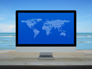 Global business words world map on desktop modern computer monitor screen on wooden table over tropical sea and blue sky with white clouds, Global business online concept, Elements of this image furni